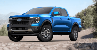 A blue 2024 Ford Ranger Lariat parked on a gravel road, with trees visible in the background.