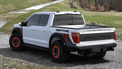 A white 2024 Ford F-150 Raptor shown from the side and parked on a gravel road, with rocks and grass shown in thee background.