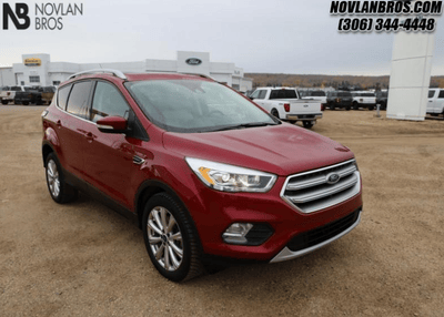 A red 2017 Ford Escape Titanium for sale at the Novlan Bros dealership in Saskatchewan.