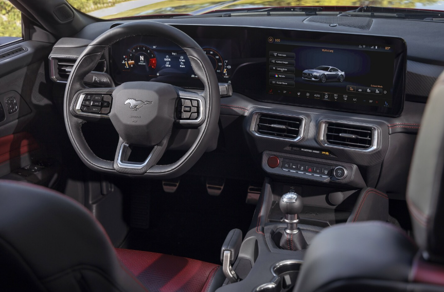 Interior view of the 2024 Ford Mustang, showing the steering wheel, dashboard, and LCD touchscreen.