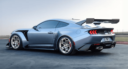 A blue 2025 Ford Mustang shown from the side and parked on a track.