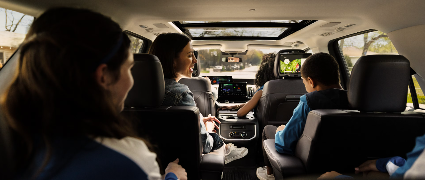 Interior view of the 2026 Ford Expedition, showing a family sitting across the three rows and using the SYNC 4 infotainment system.