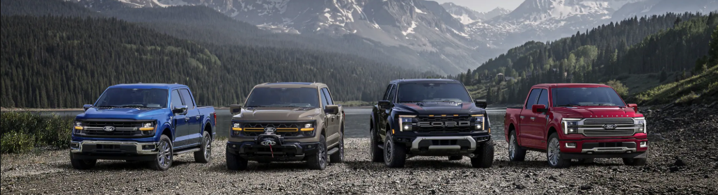 The 2025 Ford F-150 line-up parked at the edge of a cliff, with mountains and trees in the background.