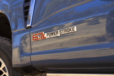Close-up of a blue 2023 Ford F-350 Lariat and its 6.7L Power Stroke Turbo-Diesel emblem.