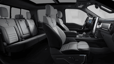 Interior view of the 2024 Ford F-150 Lightning Platinum, displaying the leather seats, dashboard, and steering wheel.