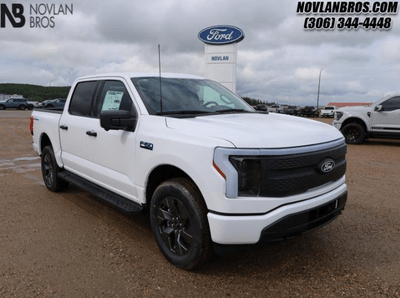 A white 2024 Ford F-150 Lightning XLT for sale at the Novlan Bros dealership in Saskatchewan.