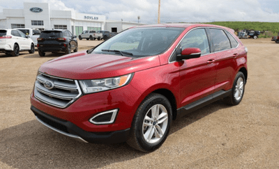 A red 2018 Ford Edge SEL for under 25,000 parked at the Novlan Bros dealer in Saskatchewan.