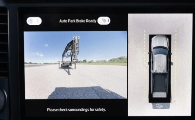Close-up of the 2023 Ford F-250 Platium's available advanced camera system, showing an image on a touchscreen as the truck reverses and notifying the driver of the Auto Park function.