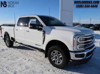 A white 2023 Ford F-350 Lariat Super Duty parked at the Novlan Bros dealership.