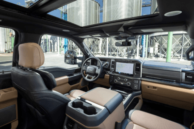 Interior view of the 2023 Ford F-350 Super Duty, showcasing the tan accents, leather seats, and SYNC 4 infotainment console.