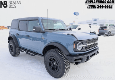 A blue 2024 Ford Bronco Wildtrak parked at the Novlan Bros dealership in Saskatchewan.