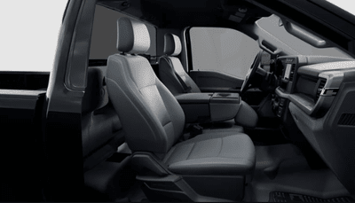Interior view of the 2024 Ford F-350 XL, showing two black seats, the console, and the dashboard.