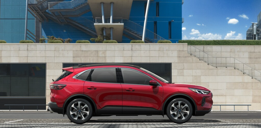 A red 2024 Ford Escape Platinum shown from the side and parked in front of a concrete structure, with a glass building in the background.