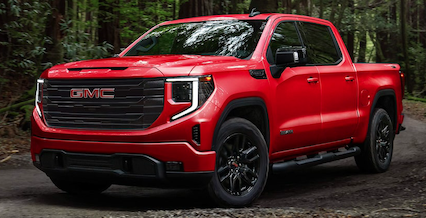 A red 2023 GMC Sierra 1500m parked in a forest.